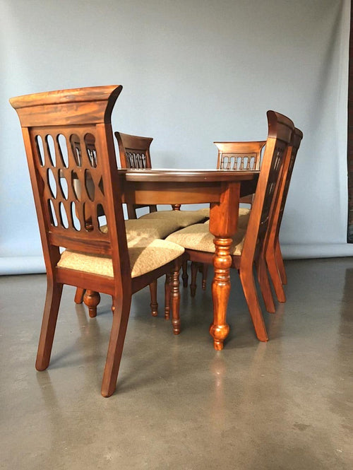 Fabrica de Muebles Wood dining set with four chairs and a table featuring turned legs and upholstered seats. Chairs have decorative cutouts.
