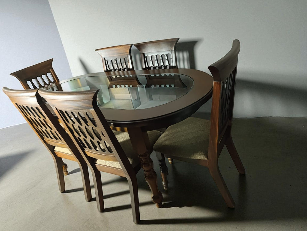 Fabrica de Muebles Wood dining set with oval glass top table and six wooden chairs with carved backs and upholstered seats.